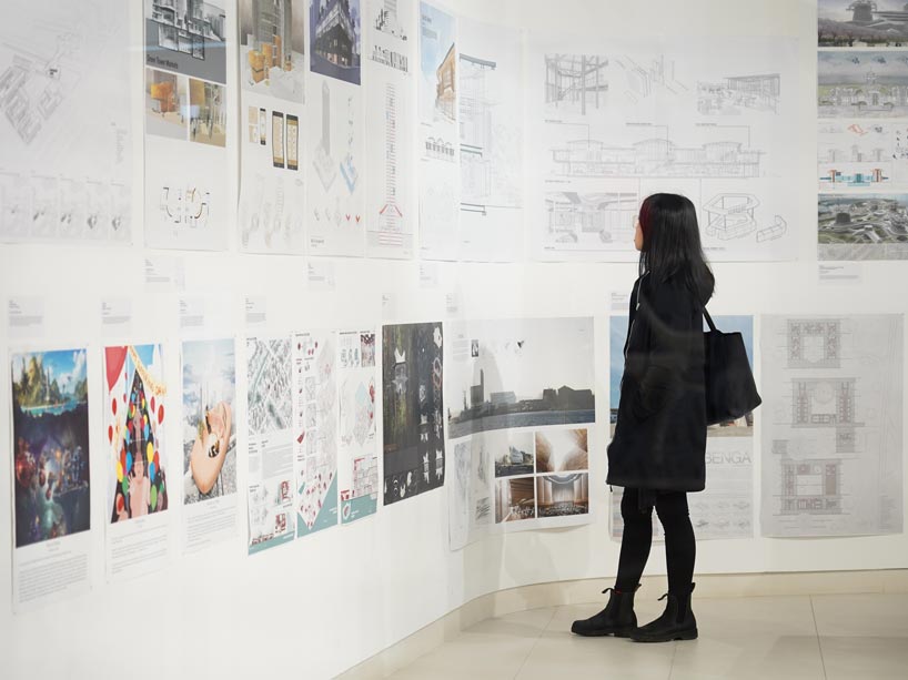 Woman facing wall of sketches and architectural drawings