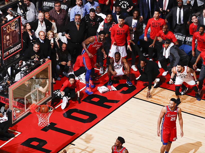 Fans and Raptors players watch the game-winning shot go in the basket