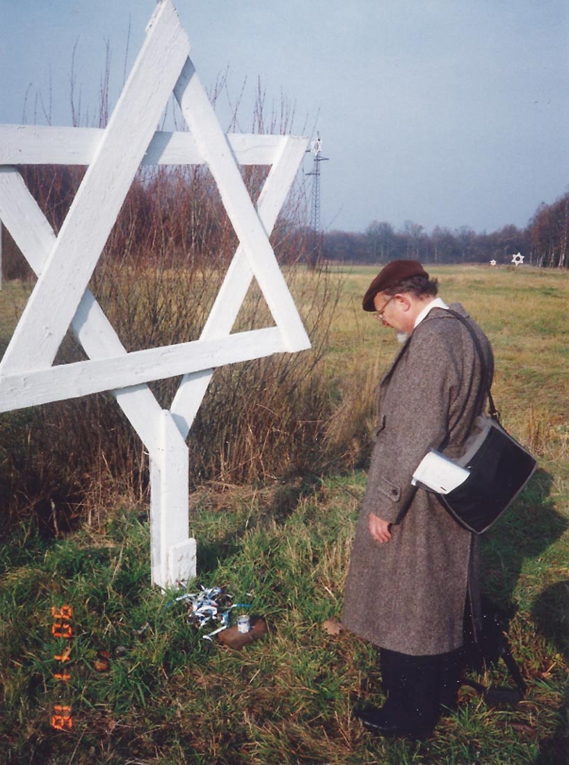 Nate Leipciger standing in front of a wooden structure shaped like the Star of David at Auschwitz