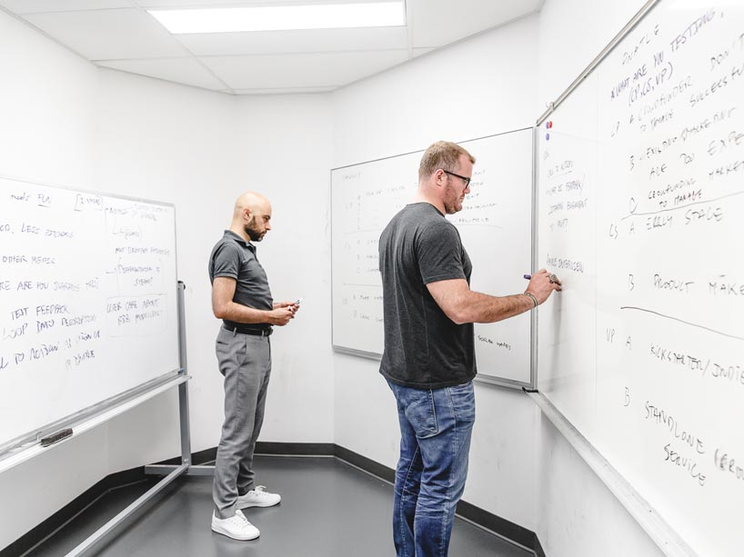 Two people working collaboratively at a white board