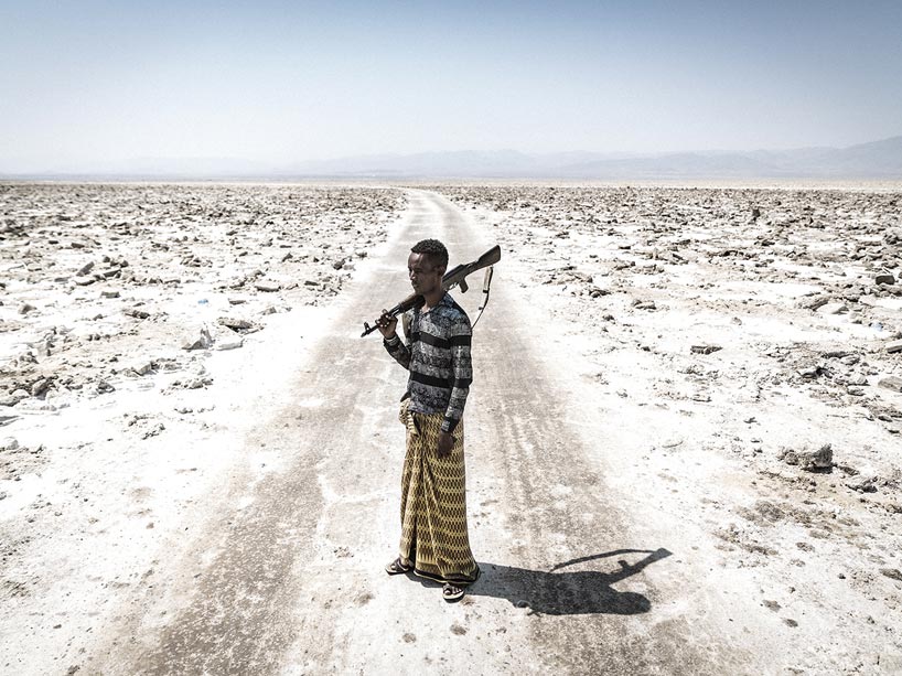 Militia soldier stands with a gun in the Danakil Desert in Ethiopia