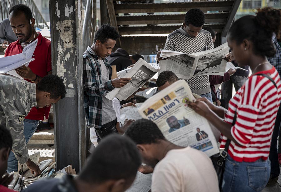 A group of people reading newspapers