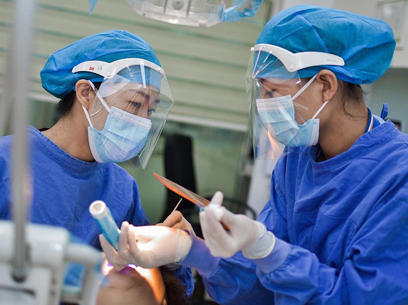 Two nurses work in personal protective equipment