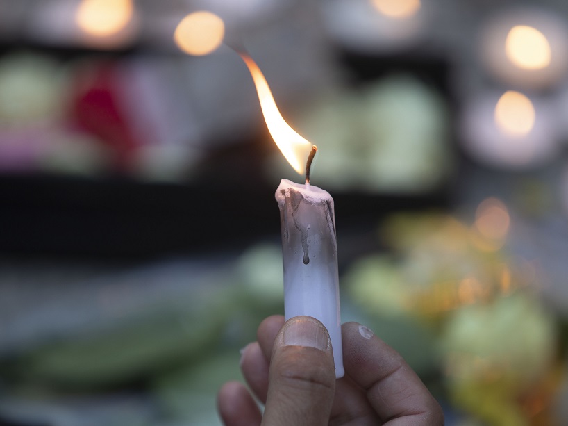 A lit candle at a vigil.