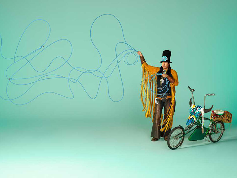 Photo of person waving blue lasso beside a bicycle.