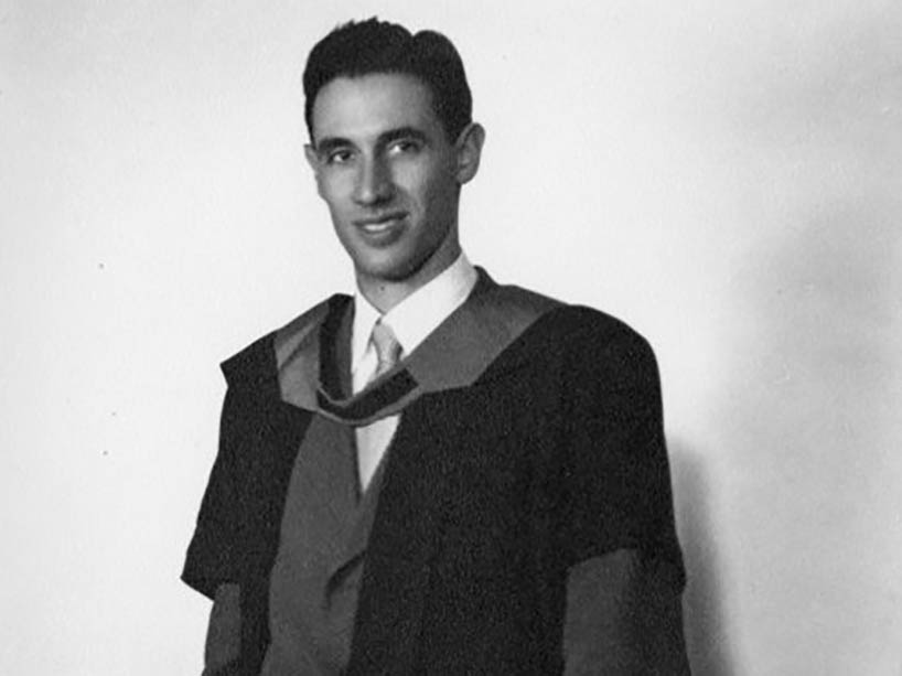 A young man wearing a graduation gown.
