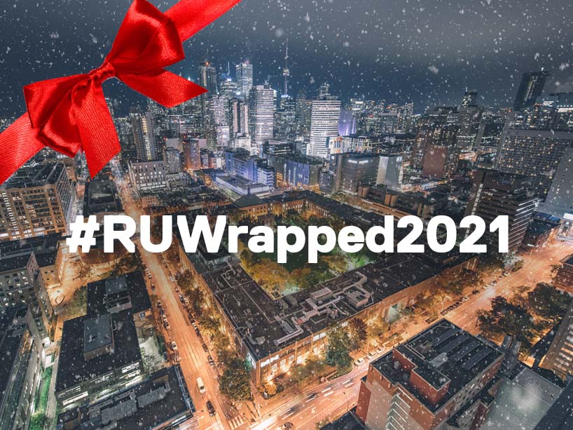 An overhead shot of the Ryerson campus at night with a red ribbon on a top corner and the text #RUWrapped2021 in the centre