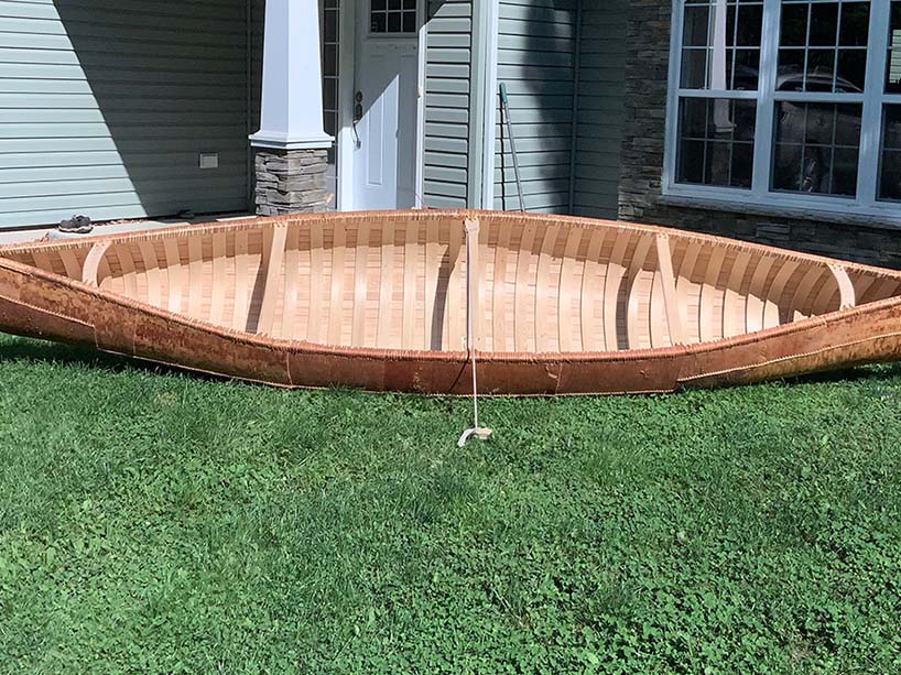 A canoe outside on grass.
