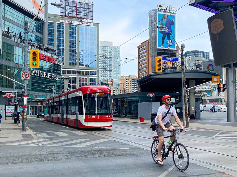 An intersection near the university campus in downtown Toronto with a streetcar and a cyclist.