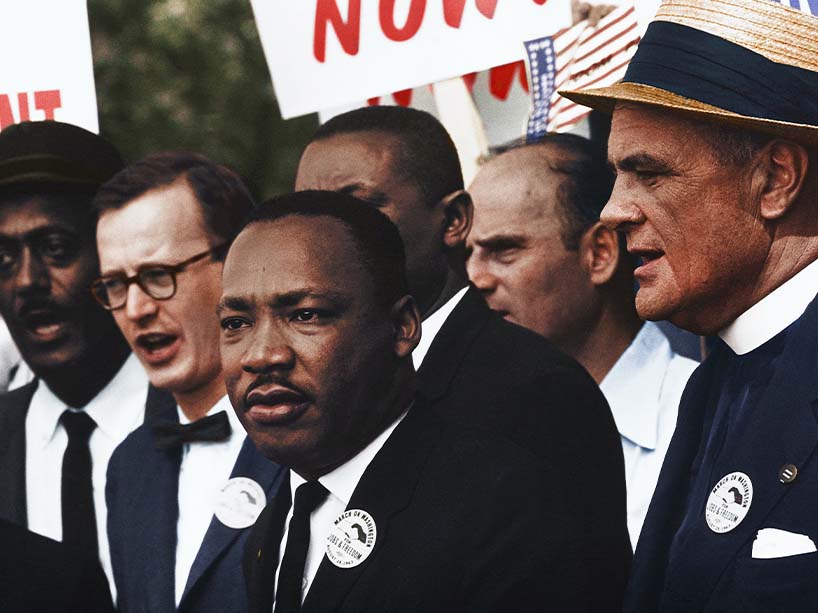 Martin Luther King Jr. stands in a crowd of people.