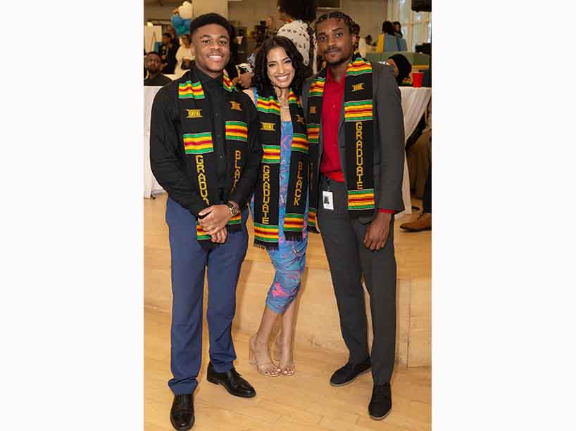 Three TMU graduates standing together.