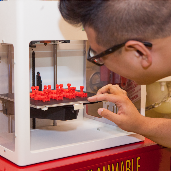 Student checking on progress of 3D printing job