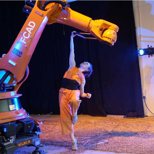 Dancer reaching up to connect with a robotic arm