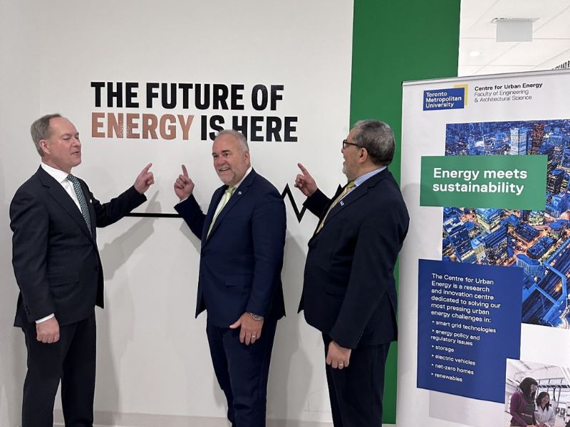 President Lachemi, Minister of Energy, Todd Smith and Minister of Finance, Peter Bethlenfalvy point at a sign that says "The future of energy is here."