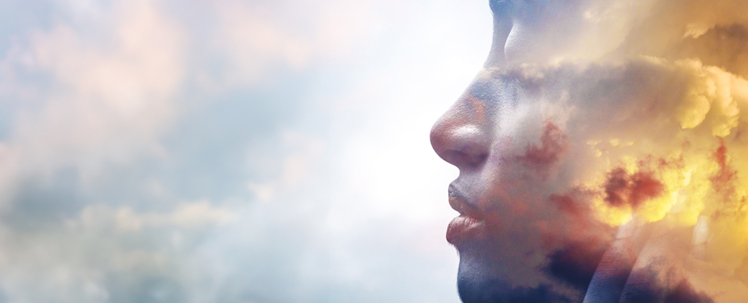 A woman’s face in profile with a gold-tinged cloudy sky superimposed.