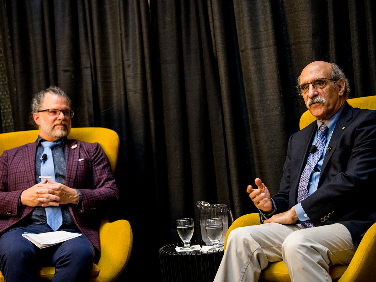 Nobel Laureate Martin Chalfie speaking alongside Dean David Cramb on-stage.