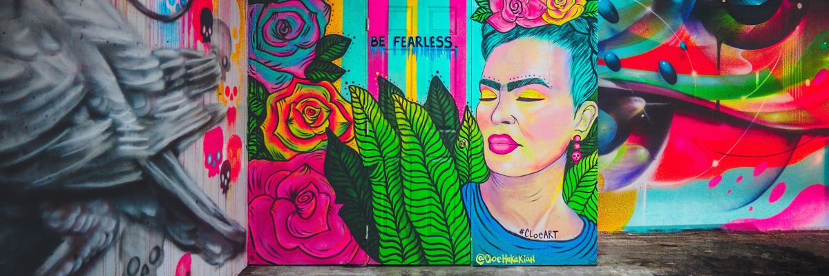 an urban mural featuring a woman in bright colours