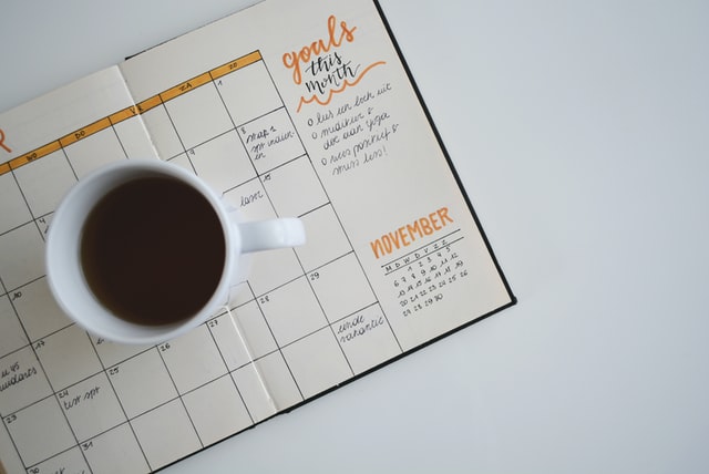 Coffee cup sitting on top of an agenda 