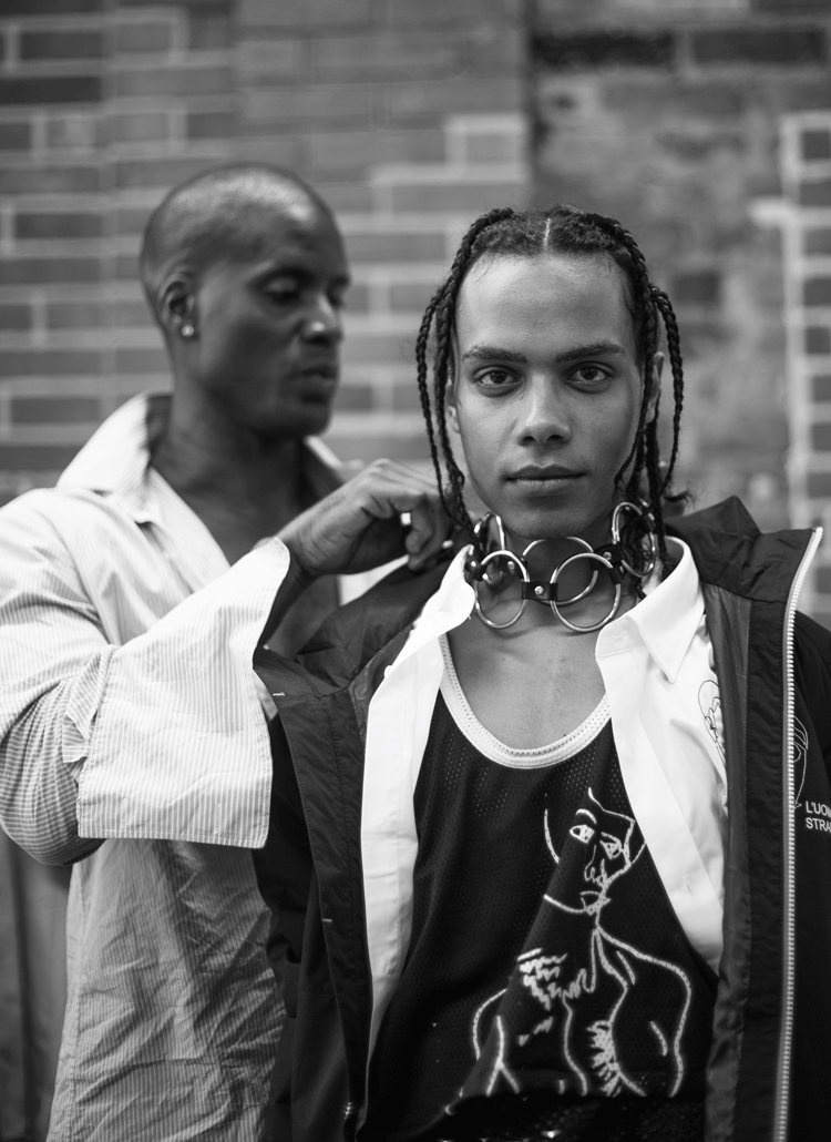 Mic Carter adjusts the necklace on a model