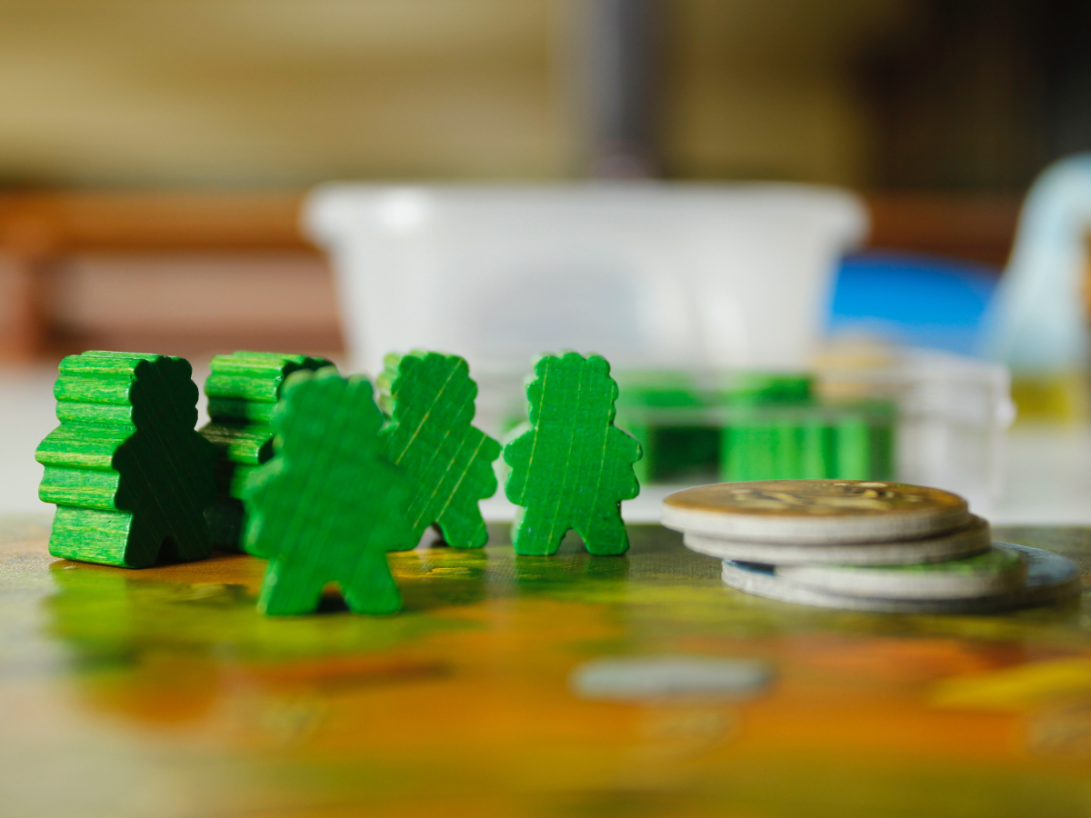 Green boardgame pieces standing on top of boardgame