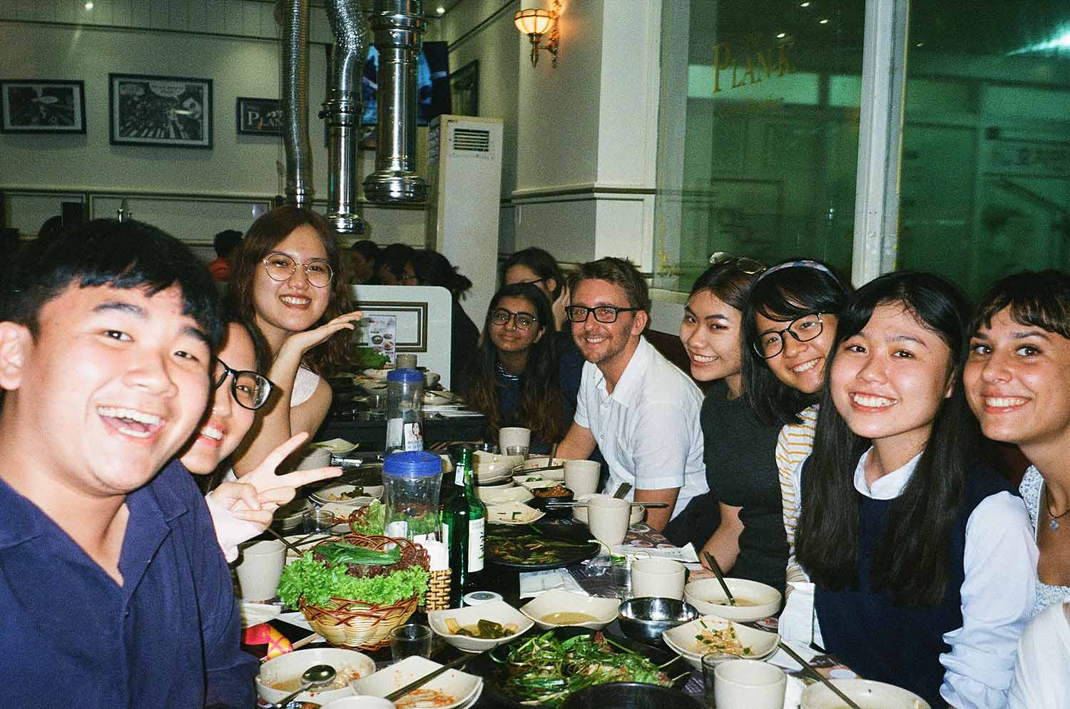 group of students at a restaurant smiling at the camera