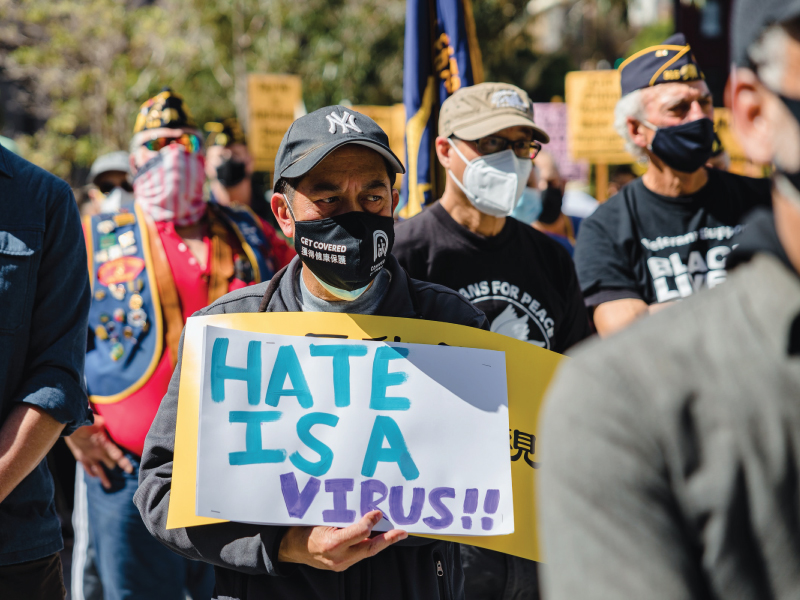 Protestor holds sign reading 'Hate is a virus'