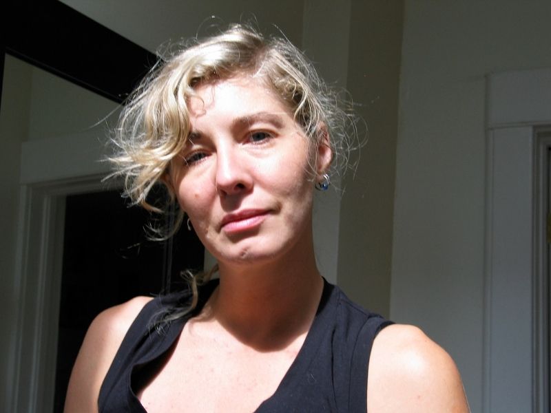 Michelle Melles wearing black shirt and her blonde hair up away form her face, looks directly at camera
