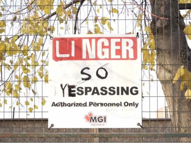 Construction sign that originally read 'Danger / No Trespassing' has been tampered with to read 'Linger so Yespassing'