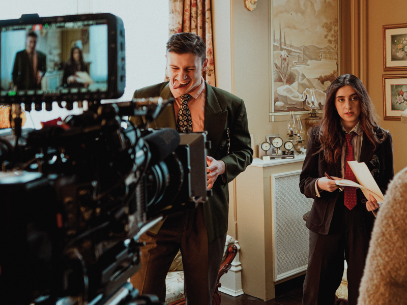 Behind the scenes of the film ‘Copping Justice.’ The image features two actors in frame with a video camera