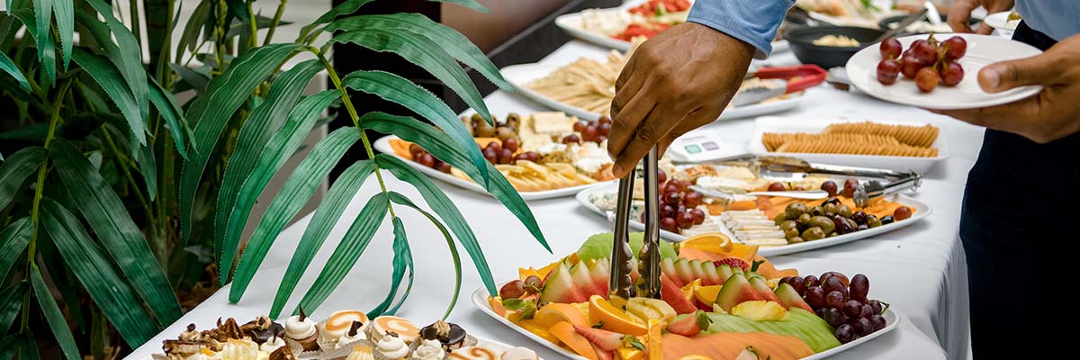 A selection of items at a catered event including fruits, cheeses, and sweets.