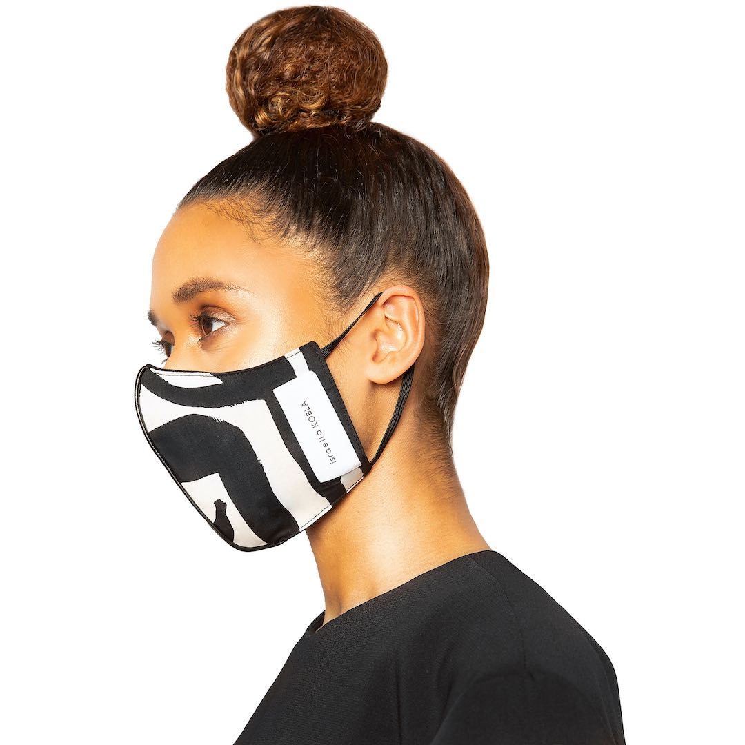 Model wearing a black and white patterned facemask by Israella Kobla